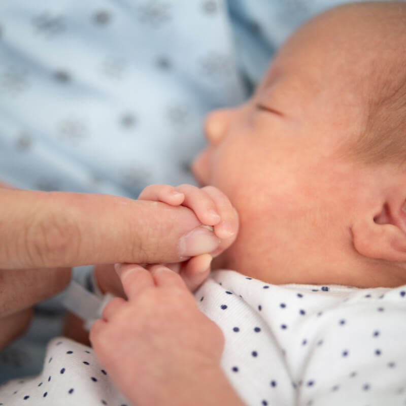 A preemie holding a finger