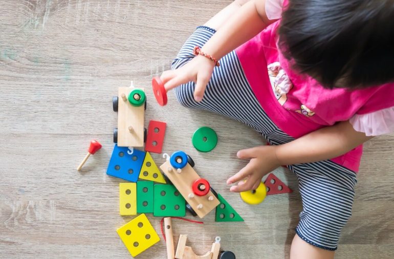 An Asian toddler is playing with educational toys
