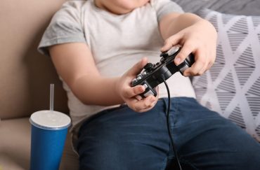 An obese boy playing games
