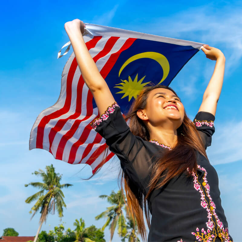 A lady holding a Malaysian flag