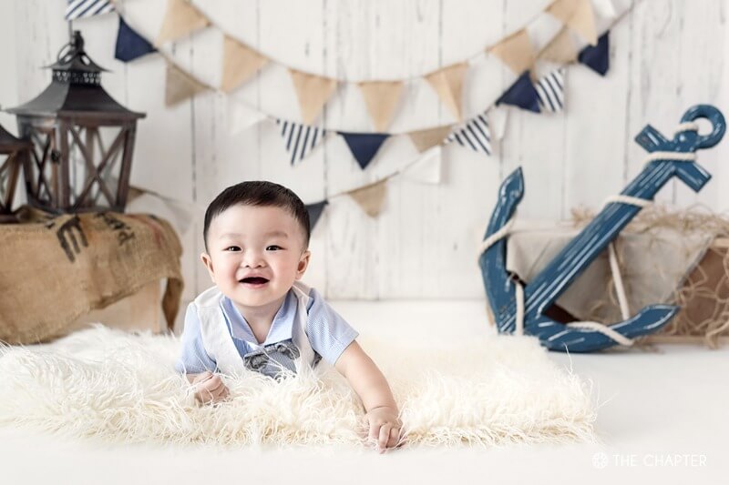 baby photoshoot with smiling baby boy on fur rug