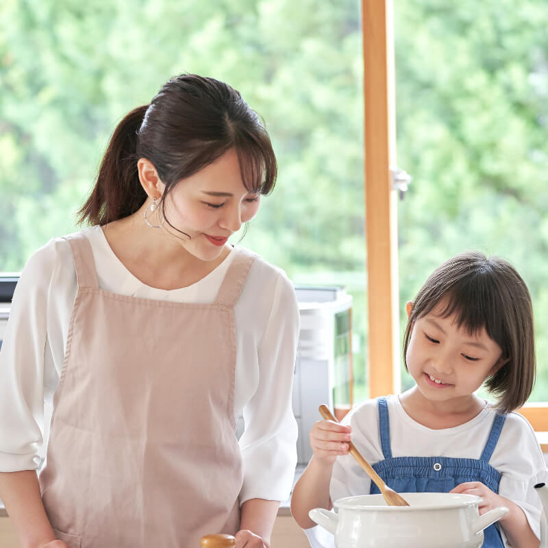 A girl cooking with her mum during school holiday