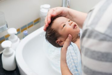 Baby taking a bath at the sink
