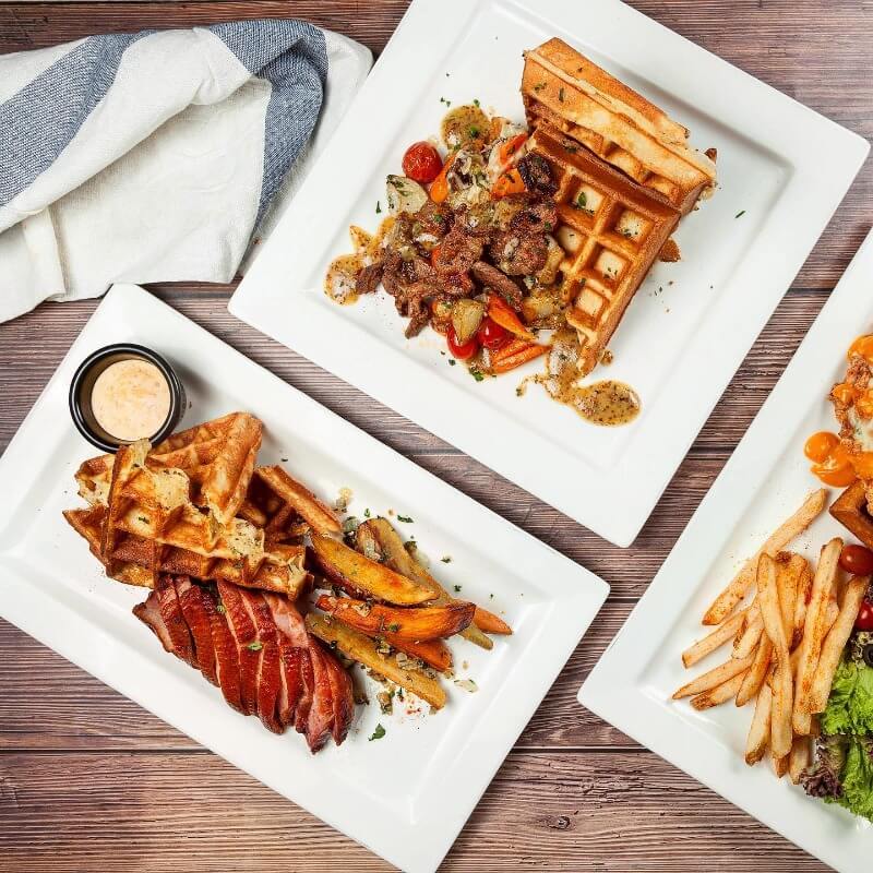 Three plates of food with fries and waffles