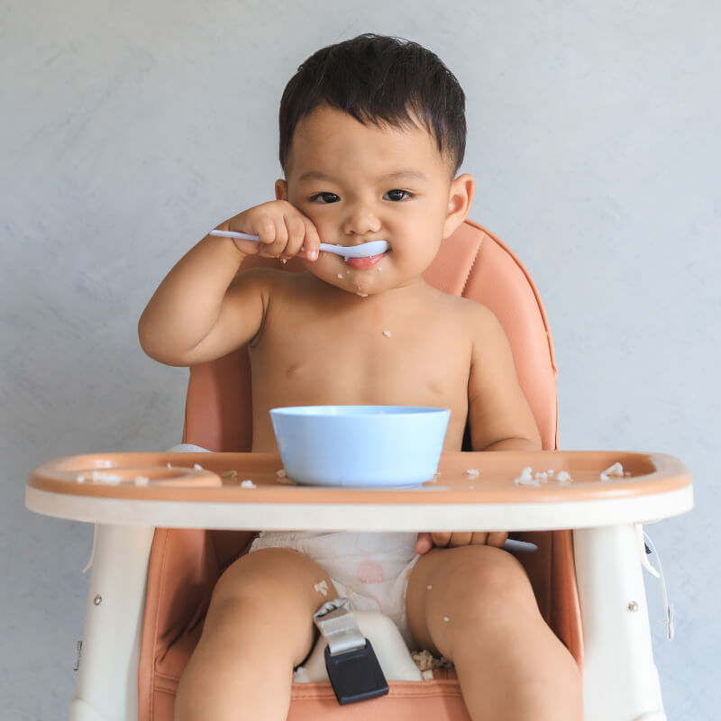 Baby eating on a high chair