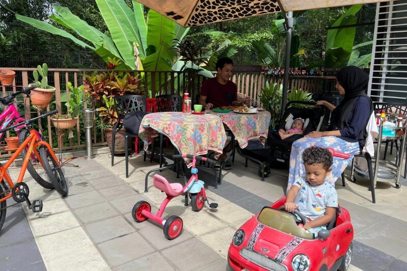 family sitting in cafe, little boy in toy car