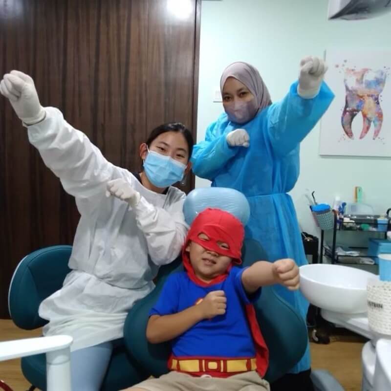 little boy in superhero costume in dentist chair