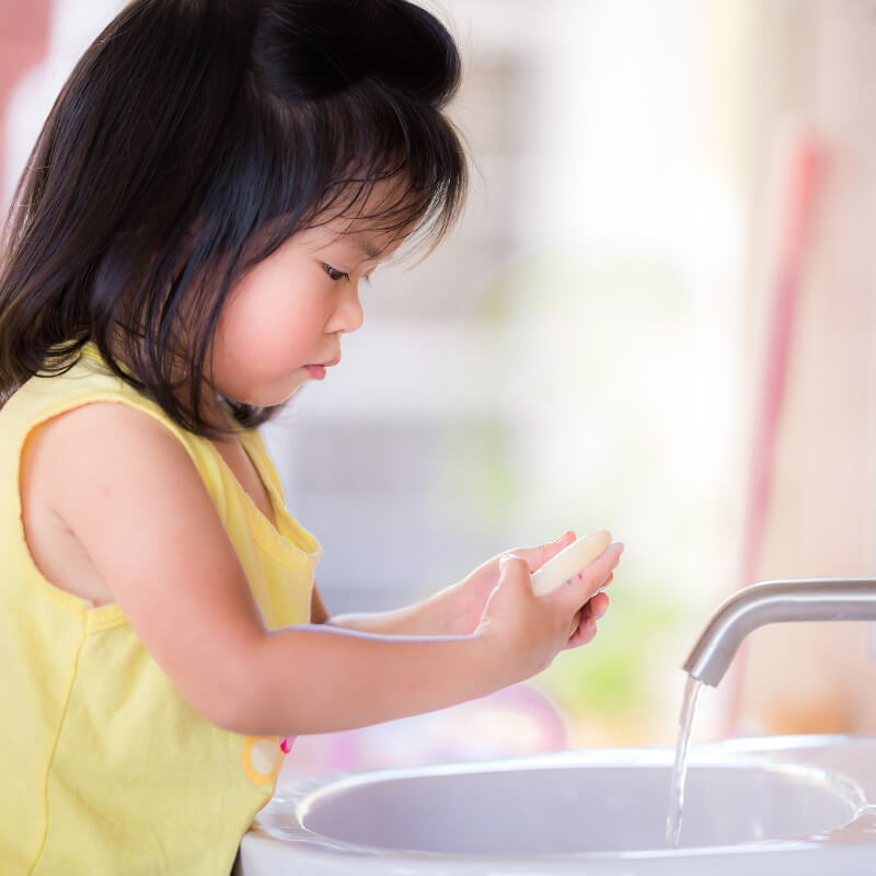 a girl washing hand as part of health literacy