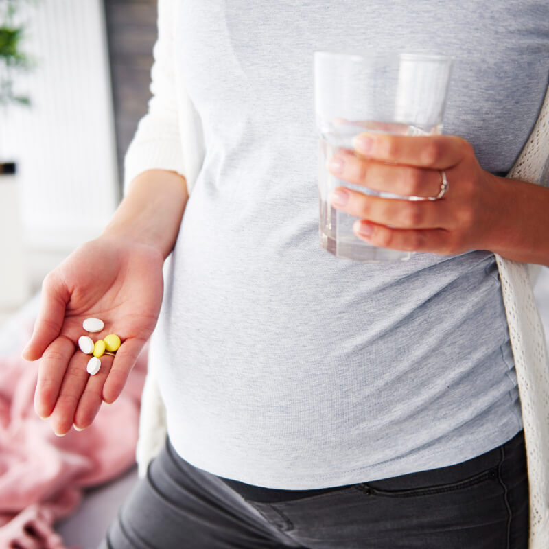 A pregnant lady eating medicine