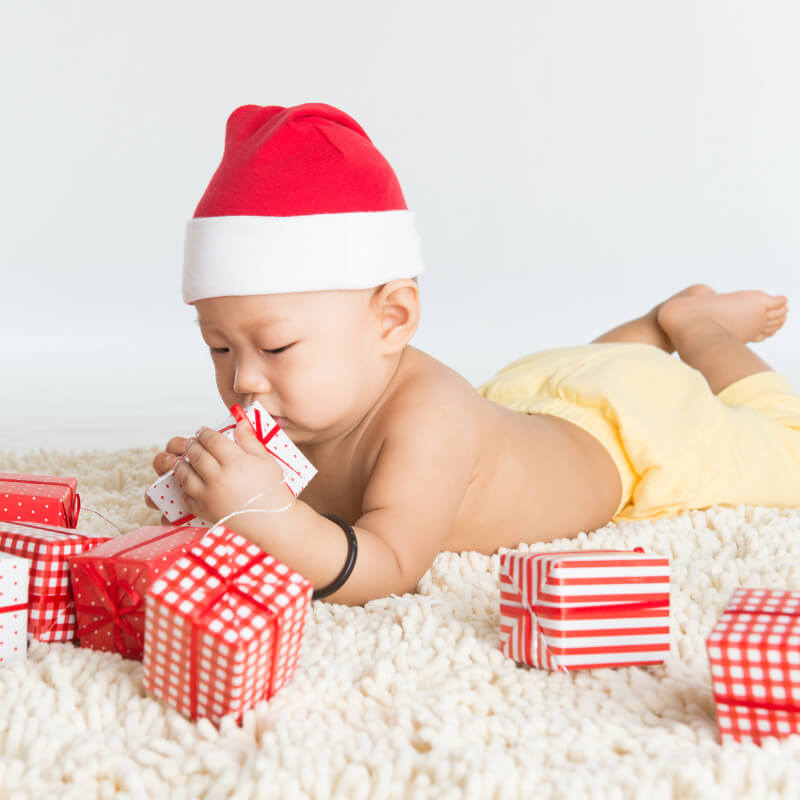 A baby with Christmas presents