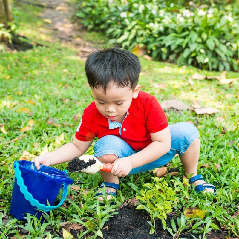 A boy putting the soil