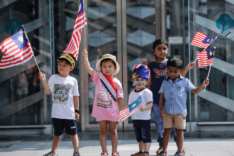 Young children holding Malaysian flags