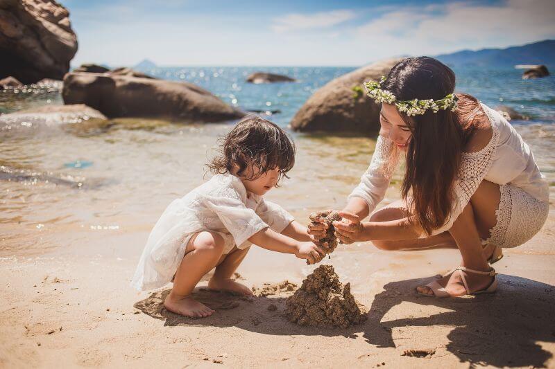 mother and child playing sand on beach activities