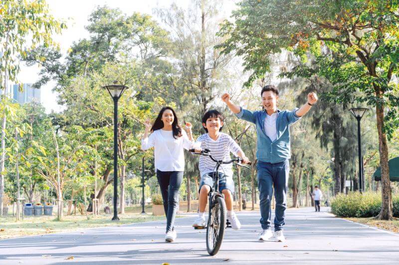 child riding bike and parents cheering