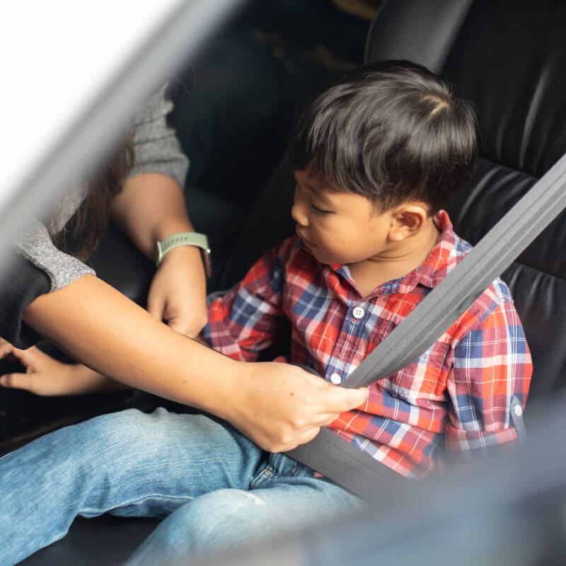 a parent putting seat belt on the kid