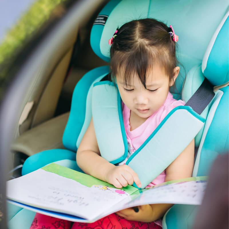 a girl reading a book in the car