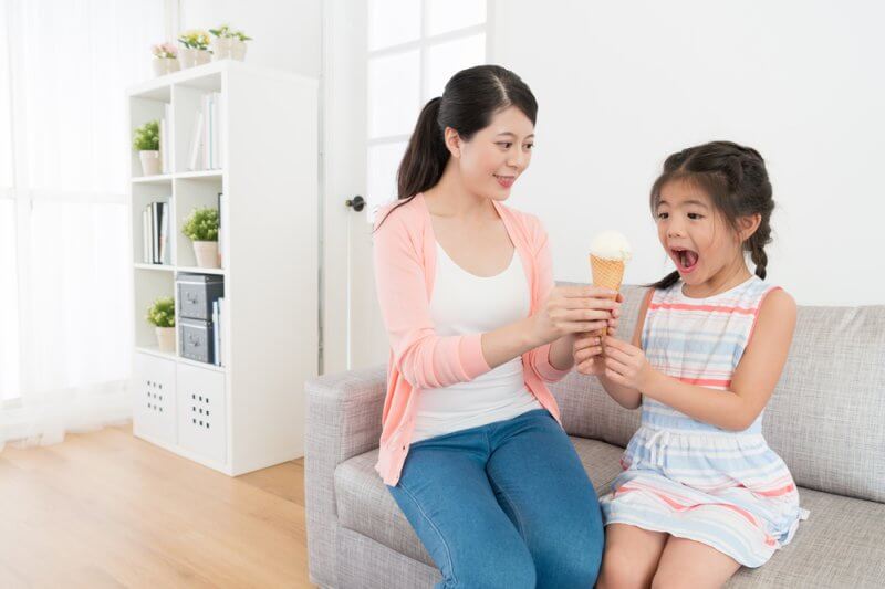 mother giving ice cream to child