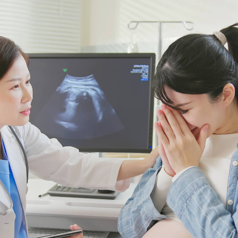 A doctor comforting a pregnant mum