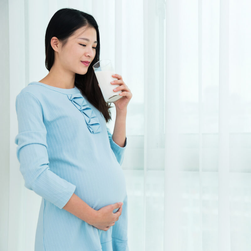 A pregnant lady drinking milk