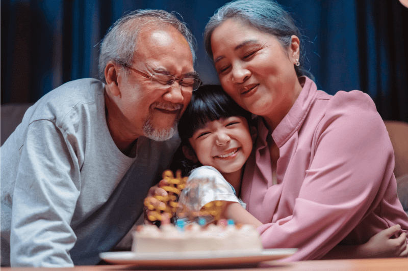 Positive Relationship Asian Grandparents hugging Child 