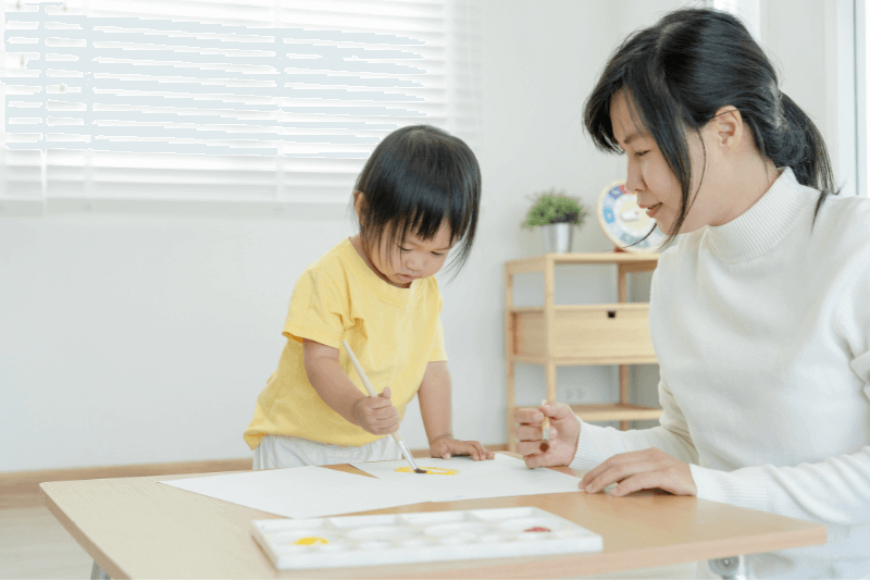 Positive Relationship Asian Child and Relative Painting Together