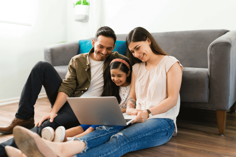 Family looking at laptop (Credit: Canva Pro)