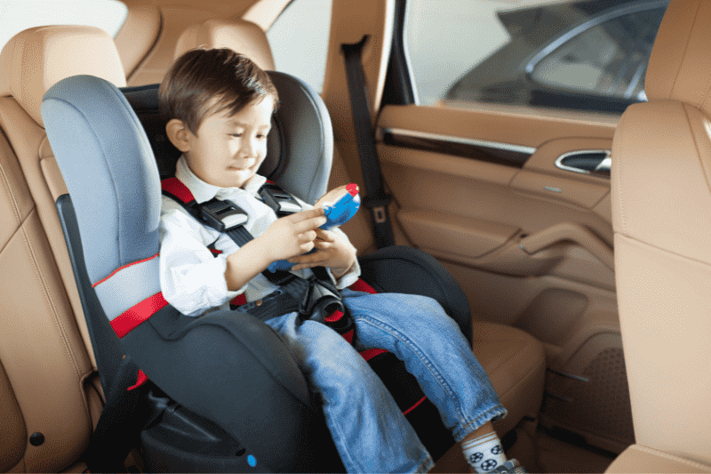toddler in car seat in middle of car back seat