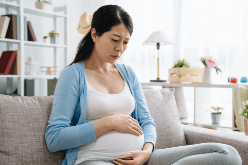 pregnant woman worried holding tummy