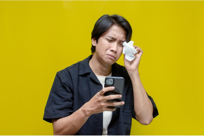 Man Crying Looking At Video in Phone