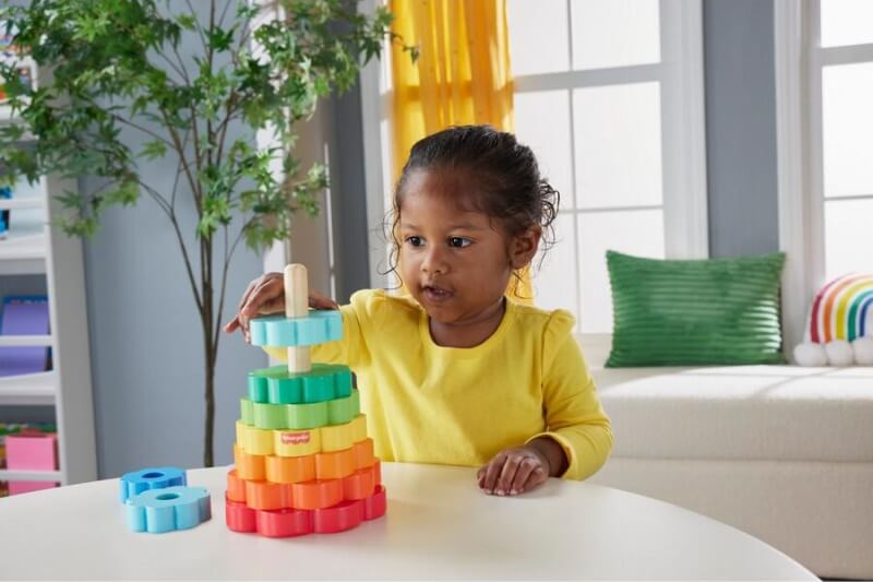 female toddler playing Fisher Price Wood Stacking Toy