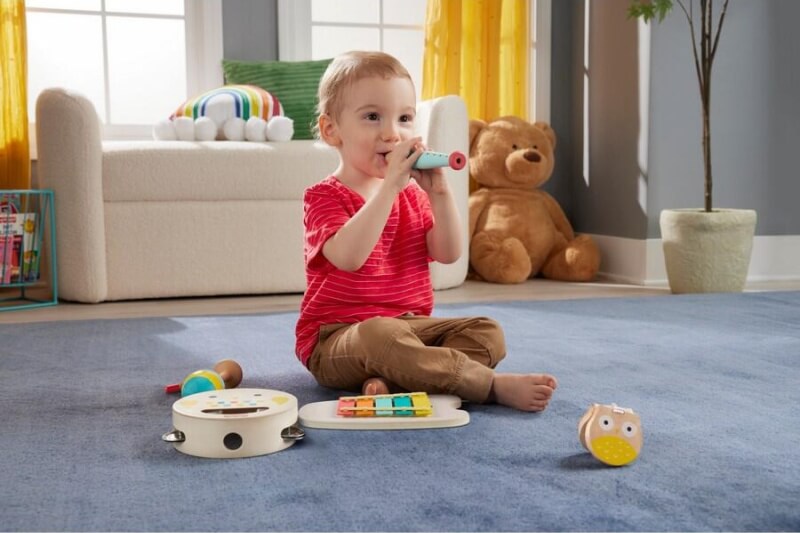 male toddler playing wooden musical toy