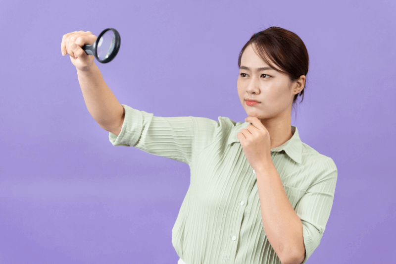 woman holding magnifying glass