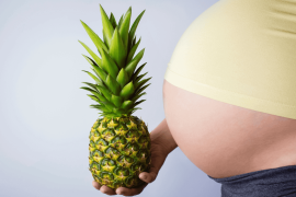 pregnant woman holding a pineapple