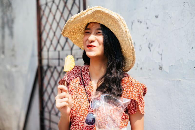 happy woman eating pineapple