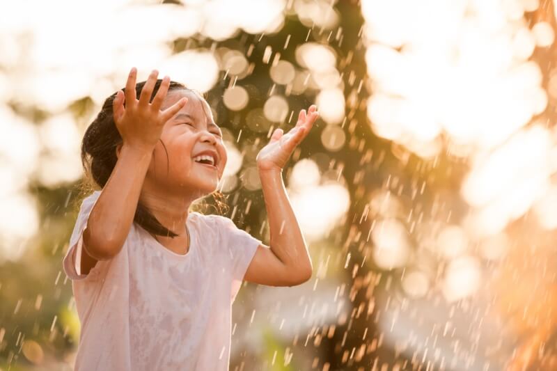 children fun in the rain enjoying childhood