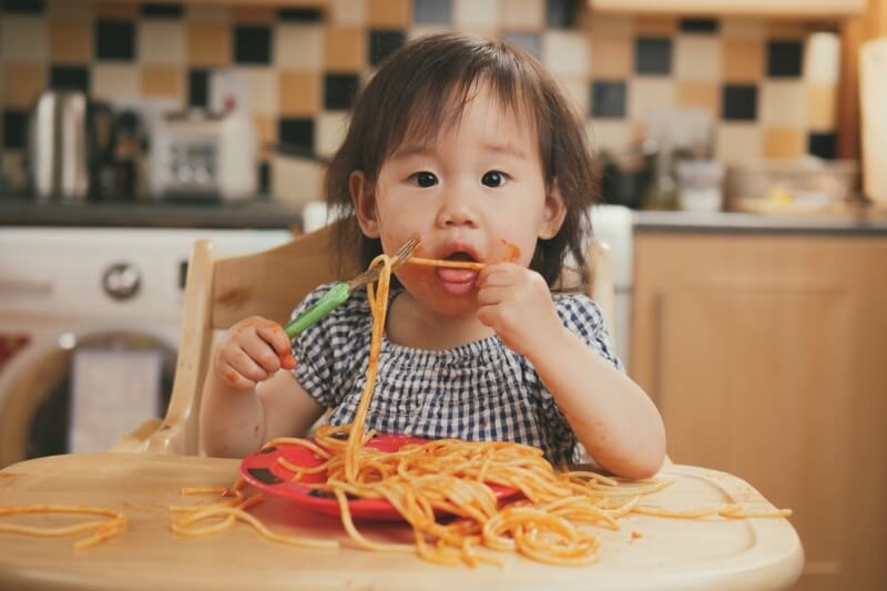 messy fun toddler enjoying pasta 