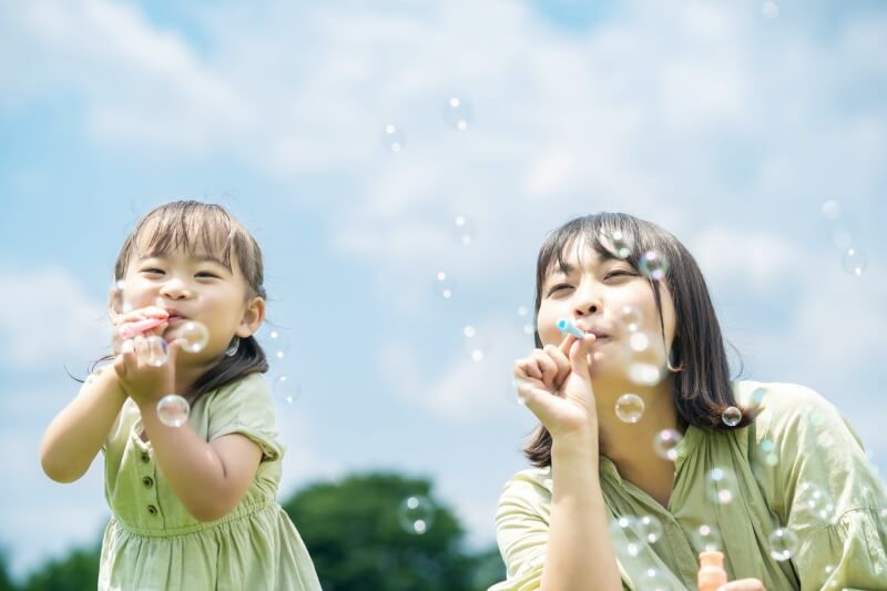 mother and daughter playing bubbles together