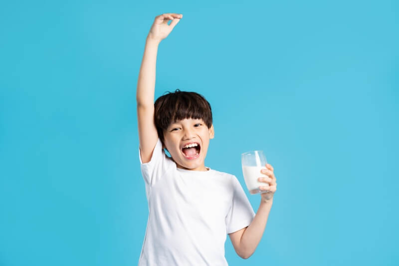 young boy enjoying glass of milk for strong bones and teeth