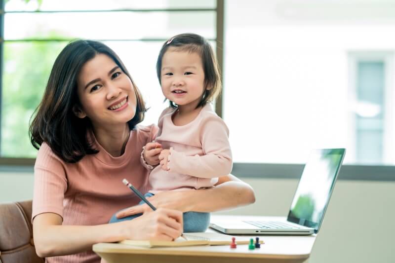 mother taking care of child while working