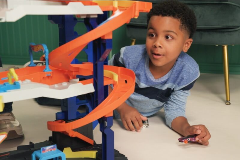 young boy playing hotwheels