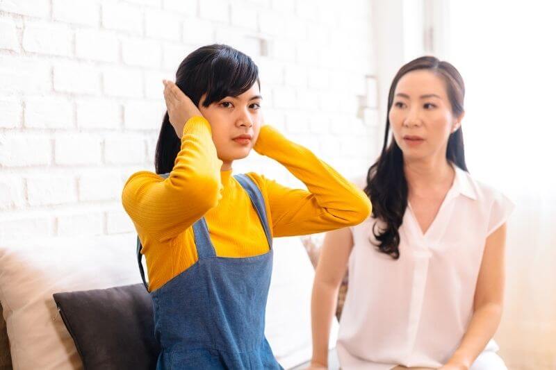 young girl refusing to hear mum