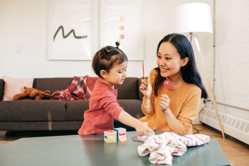 girl toddler with mother playing