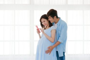 pregnant couple looking at phone