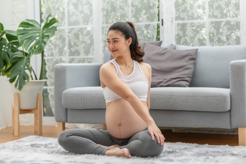 active pregnant woman on yoga mat