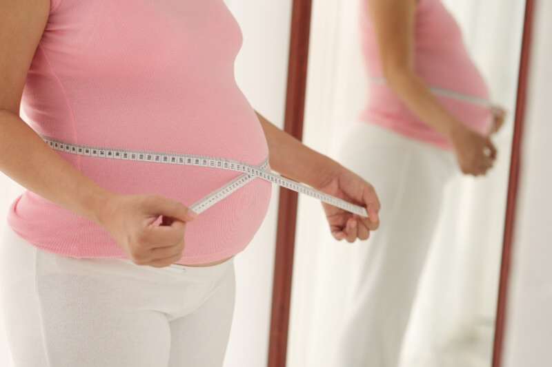 woman measuring pregnancy belly