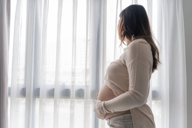 woman looking out the window concerned 