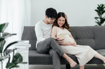 couple on sofa happy pregnant wife