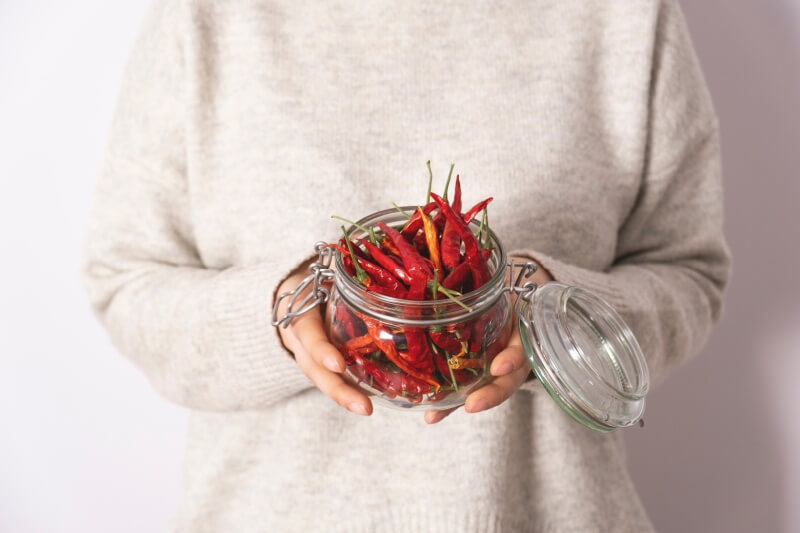 woman holding jar of spicy chili