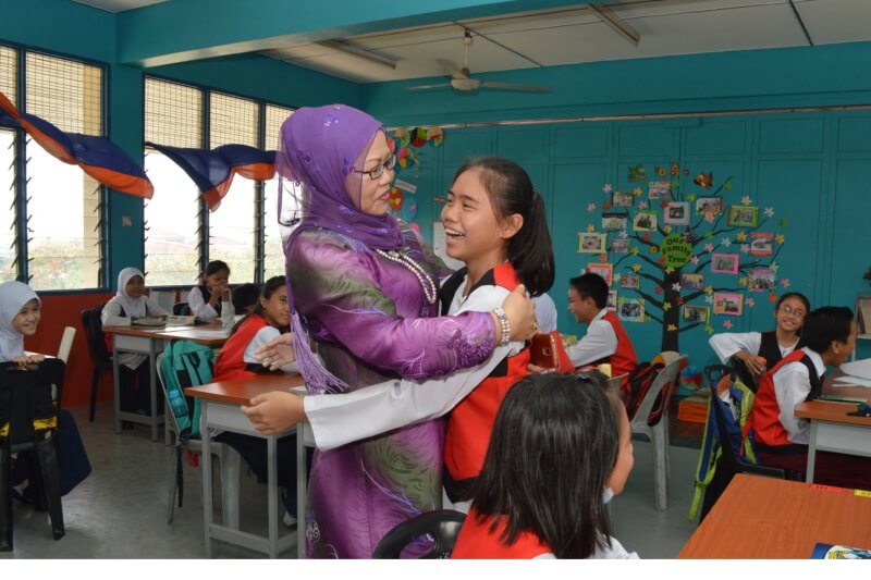 teacher hugging school student