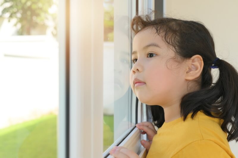 young child looking out the window.